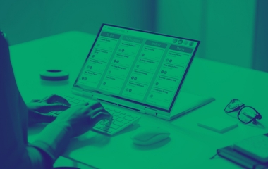 Gros plan de mains écrivant sur un ordinateur portable avec une application de calendrier affichée