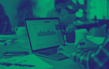 Personne dans un bureau utilisant un ordinateur portable avec des données financières affichées